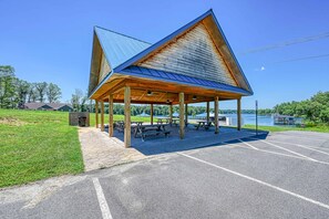 A covered picnic area with benches and a trash can, located near a body of water. - Lakefront Luxury - Beach, Dock, Deck @ Lake Anna (Mineral)