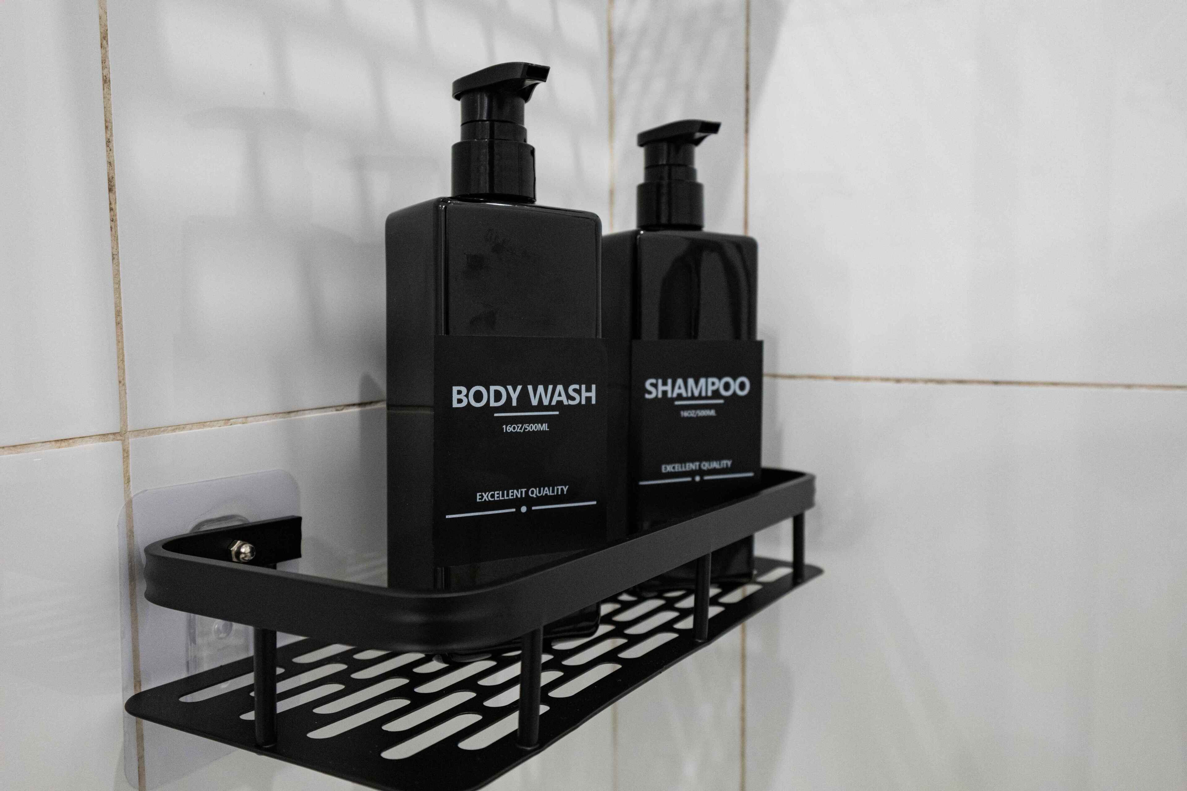 A black shelf with two bottles of body wash and shampoo.