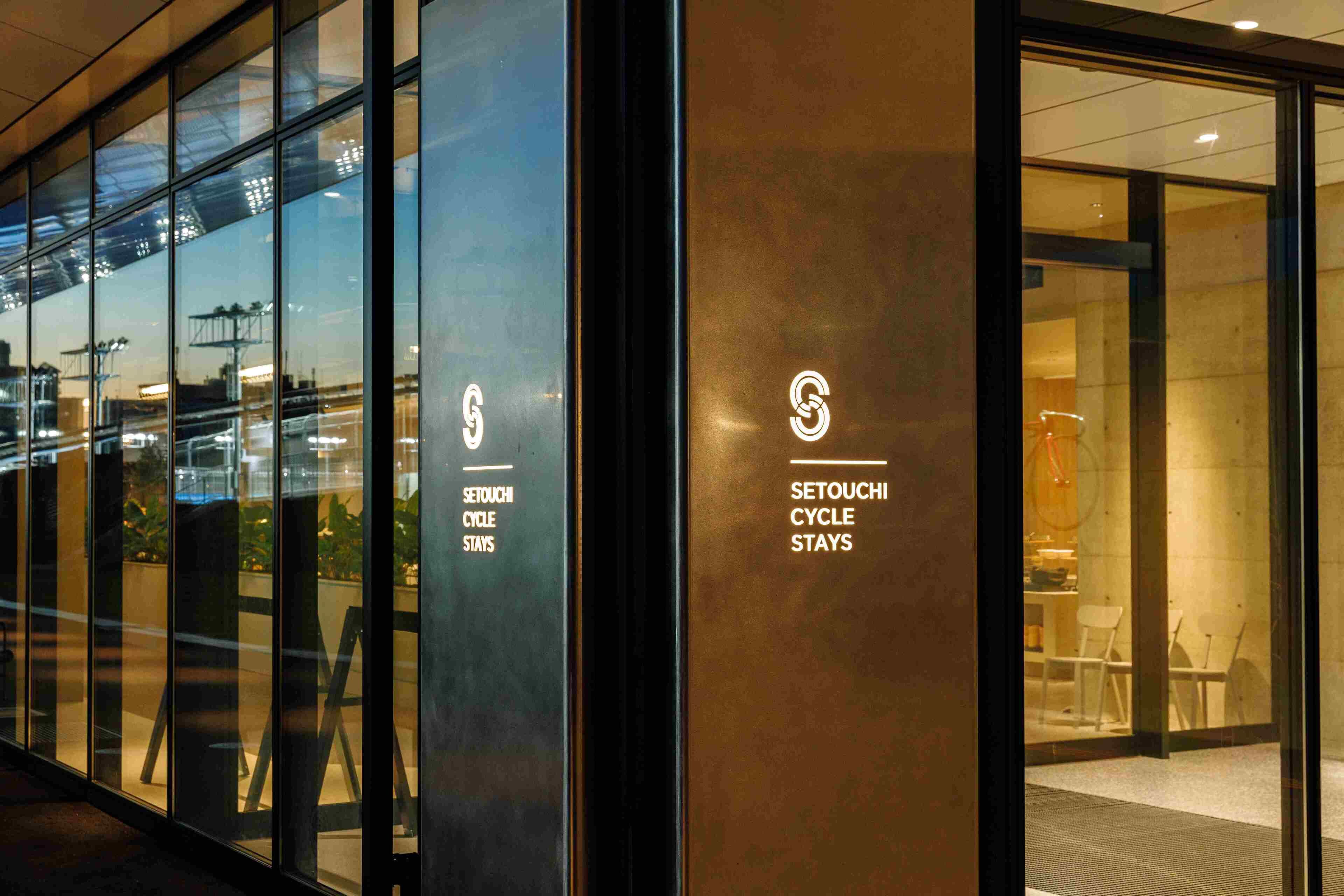 A hotel entrance with glass doors and a sign for "Setouchi Cycle Stays".