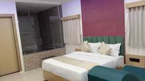 Moderni hotellihuone, jossa on suuri sänky, suihkutila ja näkymä kaupunkiin.