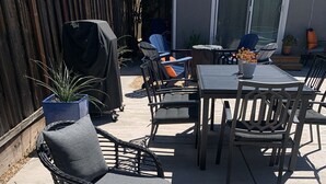 An outdoor patio area with a dining table, chairs, and a lounge chair. - Indoor/Outdoor Living in Sonoma Valley (Sonoma)