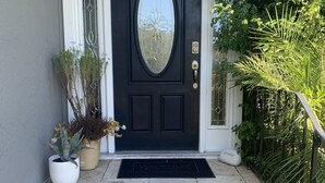 A black front door with a glass panel, a white doorbell, and a welcome mat. - Indoor/Outdoor Living in Sonoma Valley (Sonoma)