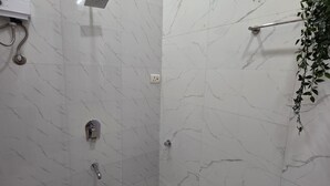 Un baño moderno con ducha, inodoro y lavamanos.