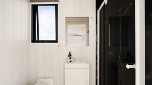 Un baño con inodoro, lavamanos y ducha.