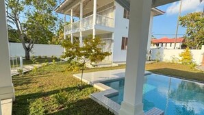 Un bâtiment à deux étages doté d’un patio couvert et d’une piscine.