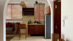 Un espace de vie compact comprenant une kitchenette, un coin repas et une chambre.