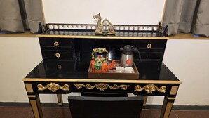 A black desk with gold accents, a tray with a teapot, cups, and a decorative item. - Studio Apartment 103 In Malabar Hill By Florastay (Mumbai)