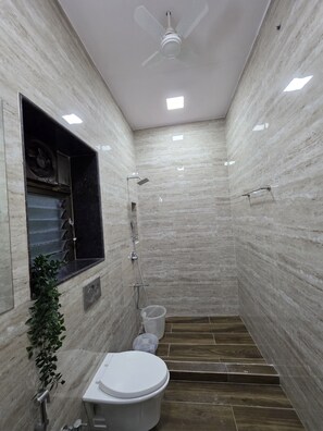 Chuveiro, toalhas de banho, sabonete, papel higiênico