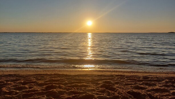 A beach with the sun setting over the water. - Cozy 2-Room Apartment on Usedom Island, Ground Floor, Perfect for 2 to 4 Guests (Pudagla)