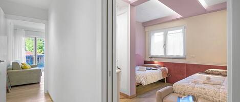 Ein Schlafzimmer mit zwei Betten, einem Schlafsofa und einem Fenster.
