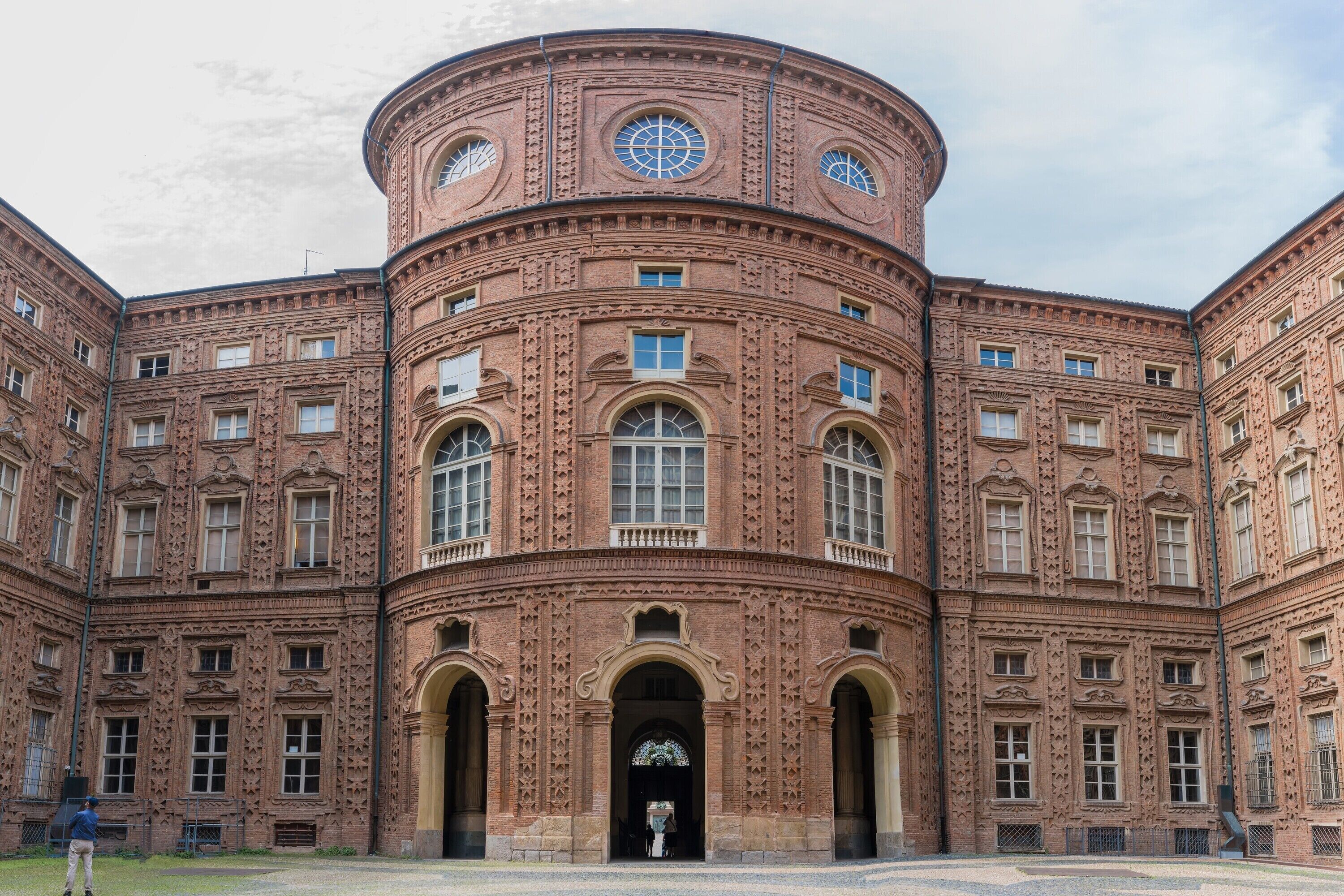 Un edificio grande y circular de ladrillo con varias ventanas y una entrada central.
