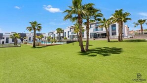 A modern hotel with a pool, palm trees, and a clear blue sky. - Modern apartment with jacuzzi Los Altos - Orihuela Costa (Torrevieja)
