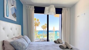 Ein Schlafzimmer mit einem großen Bett, Meerblick und einem Balkon mit Pool.