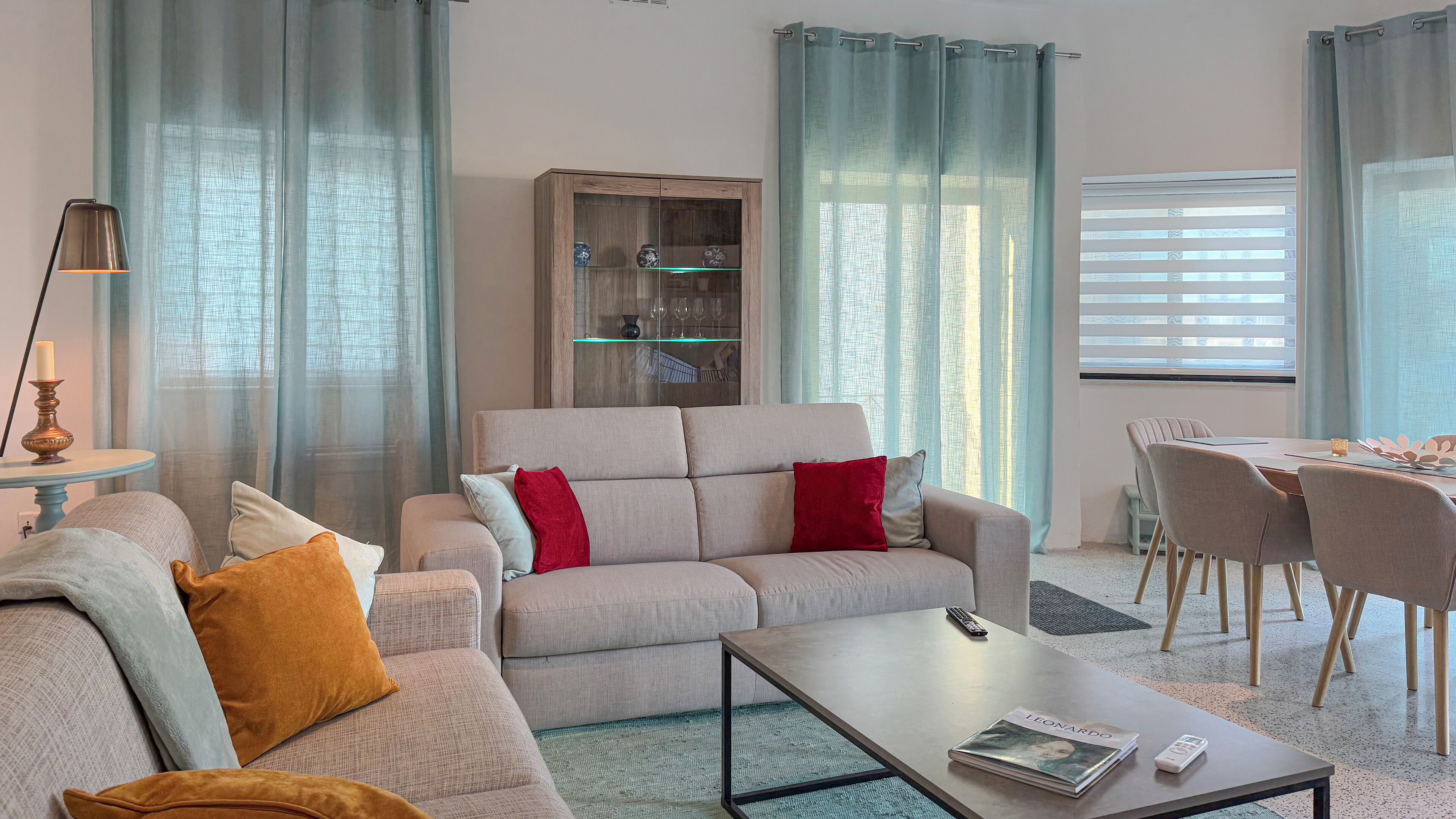 Un salon moderne avec un canapé, une table basse et un meuble vitré.