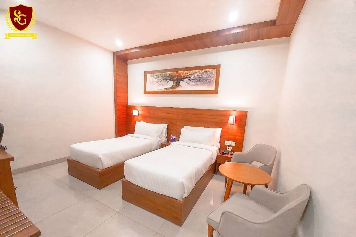 Une chambre d’hôtel avec deux lits, une petite table et une chaise.