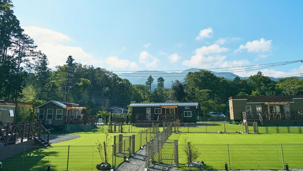 A fenced outdoor area with a small building, a wooden bridge, and a playground. - Solana Fuji Gotenba (Gotemba)