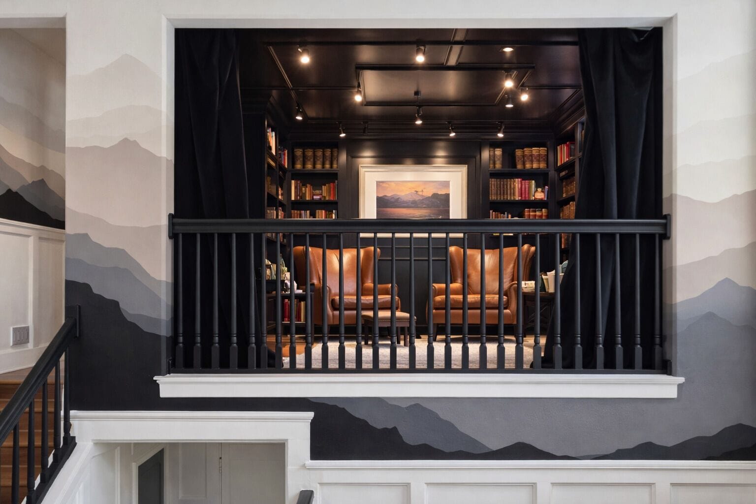 Une bibliothèque avec des étagères, des fauteuils en cuir et un tableau accroché au mur.
