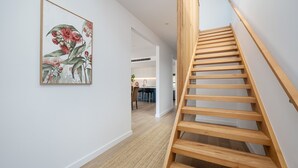 A modern interior with a wooden staircase, a kitchen area, and a dining space. - Miss Issy in Parkdale (Parkdale)