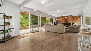 A spacious living room with a fireplace, wooden flooring, and a large sliding glass door leading to a balcony. - Buttercup cottage, Rye (Rye)