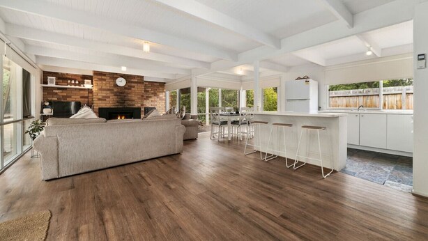 A spacious living area with a large sofa, a fireplace, and a kitchen with a bar area. - Buttercup cottage, Rye (Rye)