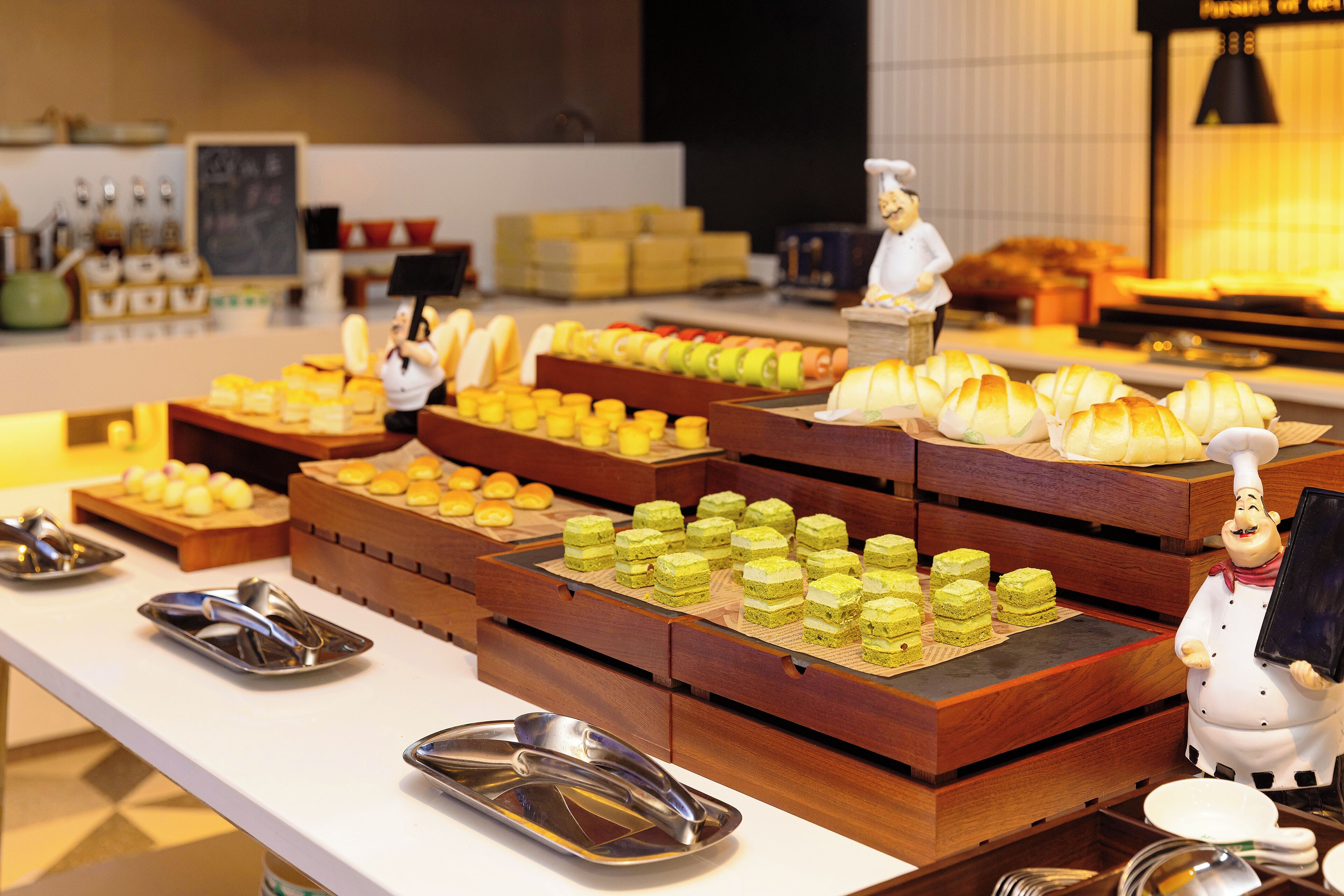Ein Buffet mit verschiedenen Speisen und einer Kochfigur.