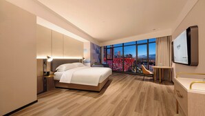A modern hotel room with a large bed, a desk, a TV, and a city view. - Echarm Hotel JiefangbeiPedestrianStreet  (Chongqing)