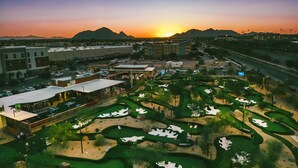 Ein Golfplatz mit mehreren Grüns und einem Parkplatz.