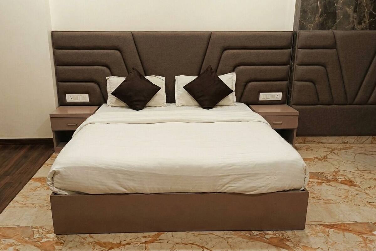 A bed with a headboard, two bedside tables, and a marble-patterned floor.
