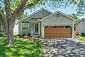 A single-story house with a garage, a front porch, and a large tree. - Castlerea Casa Columbus Home w/ Deck & Yard (Columbus)