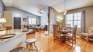A spacious living area with a wooden floor, a dining table with chairs, a kitchen area with a marble countertop, and a ceiling fan. - Castlerea Casa Columbus Home w/ Deck & Yard (Columbus)