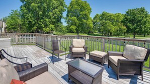 A deck with wicker furniture, a glass table, and a view of a park. - Castlerea Casa Columbus Home w/ Deck & Yard (Columbus)