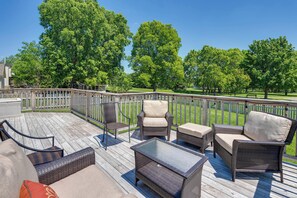 A deck with wicker furniture, a glass table, and a view of a park. - Castlerea Casa Columbus Home w/ Deck & Yard (Columbus)