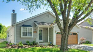 A single-story house with a front porch, a garage, and a tree in the yard. - Castlerea Casa Columbus Home w/ Deck & Yard (Columbus)