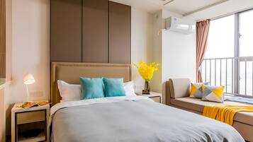 Ein Hotelzimmer mit einem großen Bett, einer Couch, einem Nachttisch mit Lampe und einem Fenster mit Vorhängen.