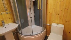 Une salle de bain avec une douche à parois de verre, un lavabo et des toilettes.