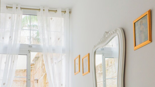 A room with a white vanity, a mirror, and a chair. There is a door leading to an outdoor area with a table and chairs. - Traditional Maisonette - Yard & Jacuzzi (Mgarr)