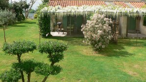 A house with a garden, a patio, and a view of a lake. - Gîte les Coquelicots facing the river (Vignonet)
