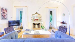 A living room with a fireplace, a television, and two sofas. - Villa Astarte: An elegant apartment located in the center of Sorrento, with Free WI-FI. (Sorrento)