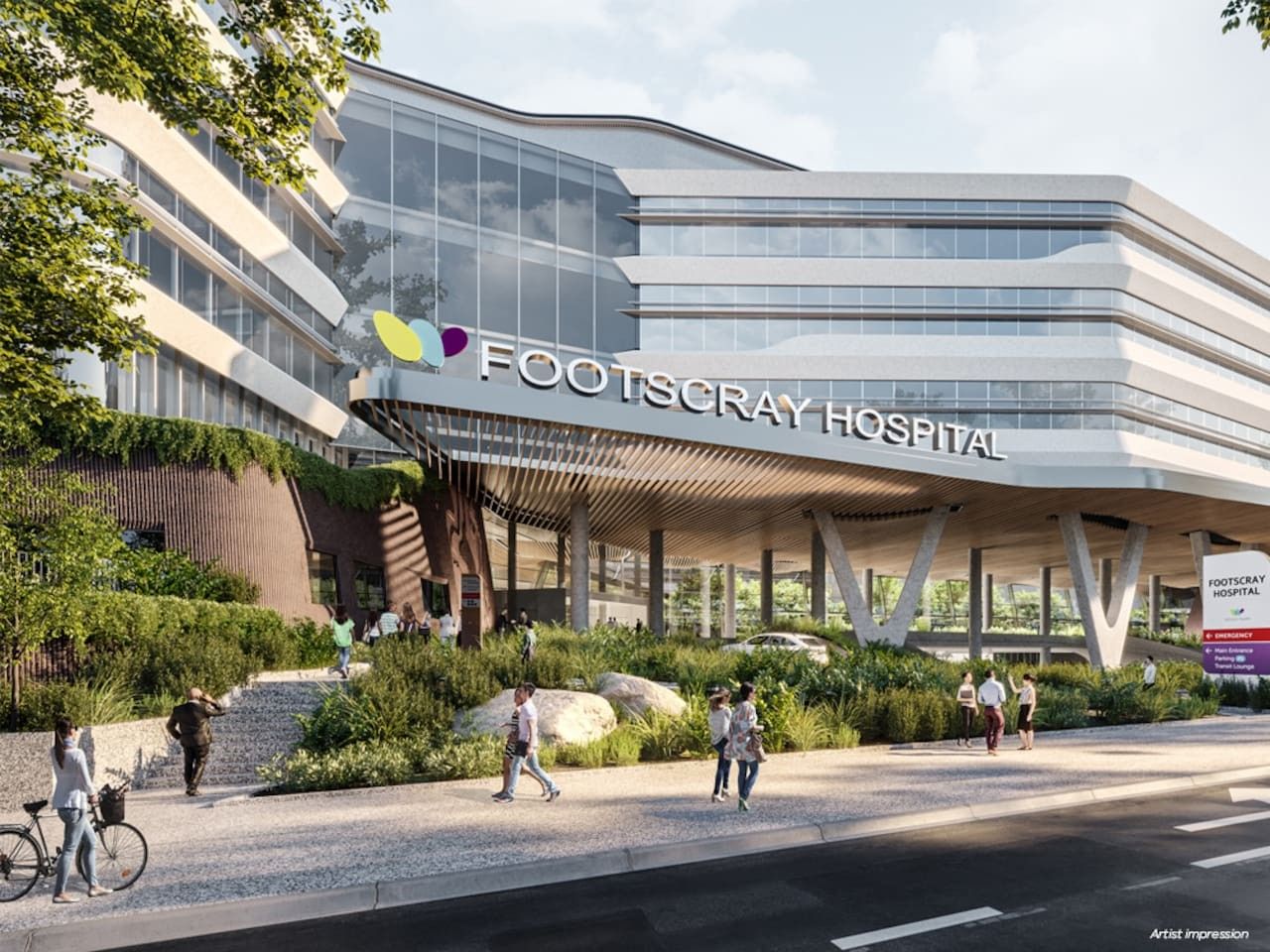 A modern hospital building with a glass facade and a covered entrance area.