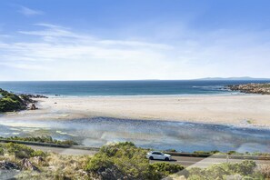 A coastal road with a beach and ocean in the background.