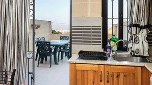 A kitchen with a wooden cabinet, a sink, and a window. - Traditional 2BR - Terrace Country Views (Qala)