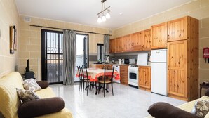 A compact living space with a dining area, kitchenette, and two sofas. - Traditional 2BR - Terrace Country Views (Qala)