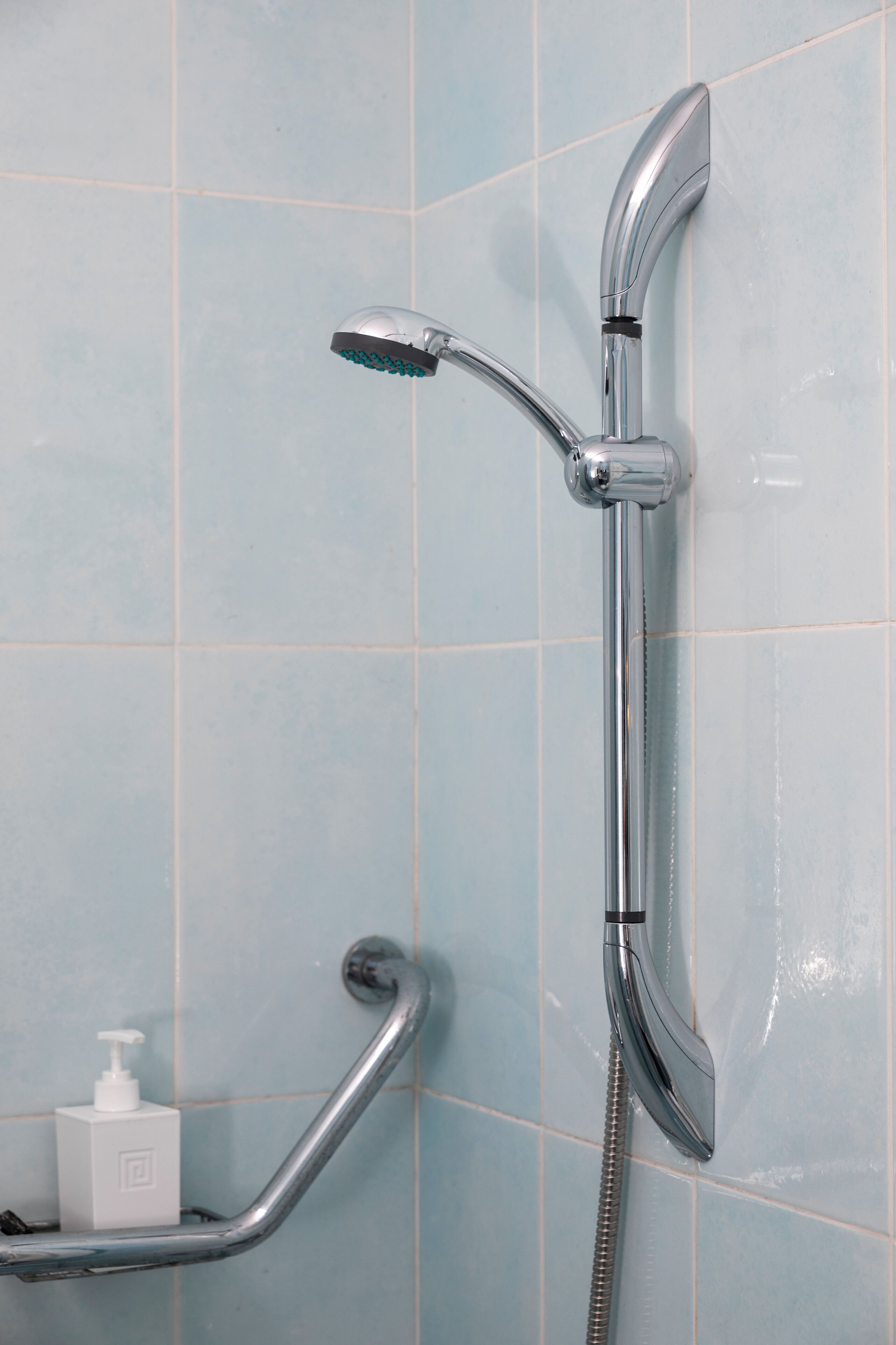A shower with a handheld showerhead and a handheld hose.