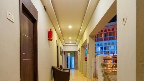 A hotel corridor with a tiled floor, a reception desk, and a fire extinguisher on the wall. - Hotel Dolphin Puri (Puri)