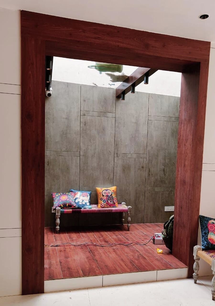 A room with a wooden bench, a wall-mounted camera, and a power outlet.
