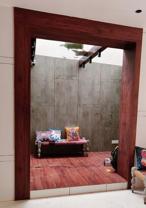 Une pièce avec un banc en bois, une caméra fixée au mur et une prise de courant.