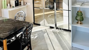 Un intérieur moderne comprenant un coin repas, un comptoir de cuisine et un escalier menant à l’étage supérieur.