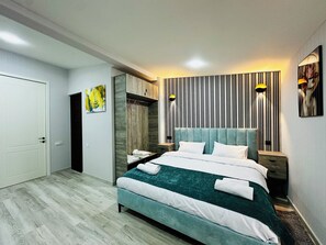 Een moderne slaapkamer met een groot bed, een kledingkast en een spiegel.