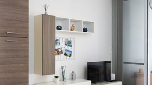 A modern living room with a white cabinet, a TV, and decorative items. - 3BR Country Retreat with Large Terrace (Zebbug)