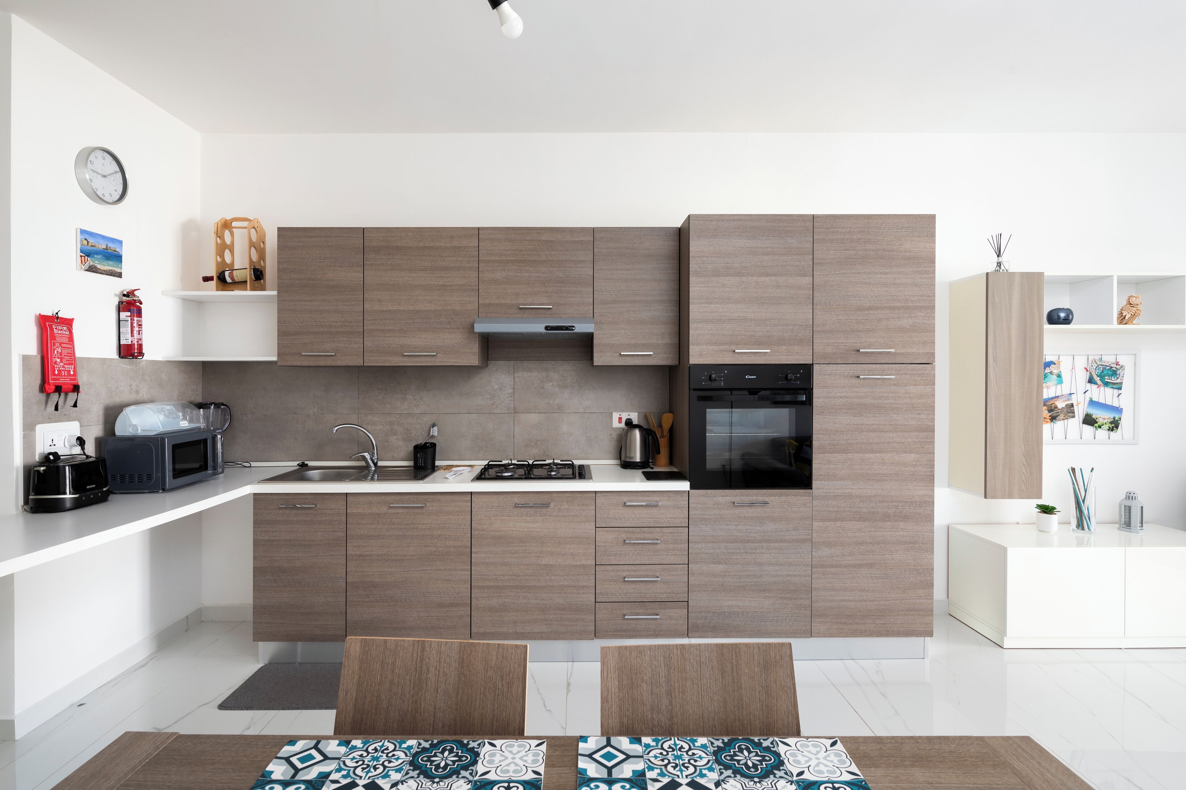 A modern kitchen with wooden cabinets, a gas stove, a microwave, and a sink.